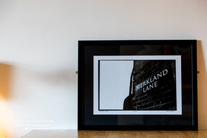 A photograph in black and white is pictured of a limited edition print of Merkland Lane, Pittodrie Stadium. Print is numbered and limited to 100 prints.