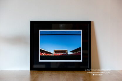 A photograph of a framed limited edition print called Pittodrie Bar. Shoing a photograph taken in the goal mouth with the goal posts bar on show at the top of the picture. taken at Pittodrie Stadium.