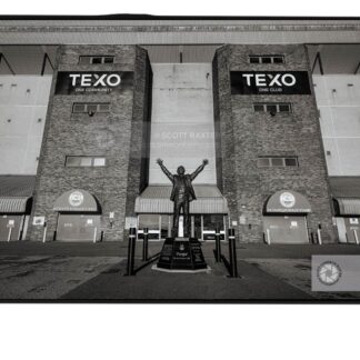 Aberdeen photographer Scott Cameron Baxter photographs the Alex Ferguson Statue at Pittodrie Stadium. The image is in Black and White, Pittodrie Stadium in the background with the ALex Ferguson Statue in the centre of the image.