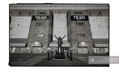 Aberdeen photographer Scott Cameron Baxter photographs the Alex Ferguson Statue at Pittodrie Stadium. The image is in Black and White, Pittodrie Stadium in the background with the ALex Ferguson Statue in the centre of the image.