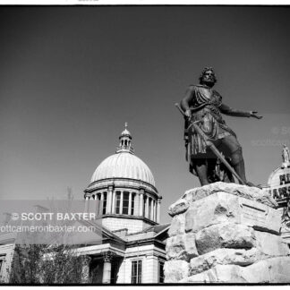 Photograph of William Wallace Statue in Aberdeen Scotland, Image is looking up at the statue which dominates the frame, the image is in upright portrait, black and white with the sun hitting the statue. Picture taken by Aberdeen photographer Scott Cameron Baxter.